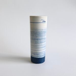 Vintage keramische vaas met cilindervorm, wit en blauw glazuur met golfpatroon en vogeltjesmotief.