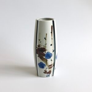 Vintage Japanse keramische vaas met cilindrische vorm, versierd met blauwe bloemen en bruine takken in minimalistisch Aziatisch design.