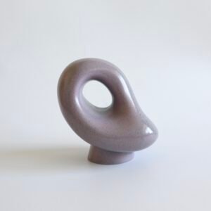 Lila handgemaakte keramische sculptuur met organische vormen en doorlopend gat in het centrum.