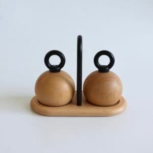 Bodum Richard Nissen peper- en zoutstel met twee ronde houten bollen, zwarte handvaten en centrale zwarte houder op houten voet.