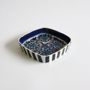 Vintage Royal Copenhagen fajance schaal met vierkante vorm, gestreepte zijkanten in blauw-wit en bloemmotief in het midden.