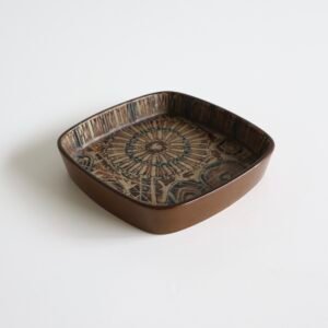 Bruine Royal Copenhagen fajanceschaal met geometrisch ornamentaal patroon en bloemmotief, midcentury design met rechthoekige vorm.