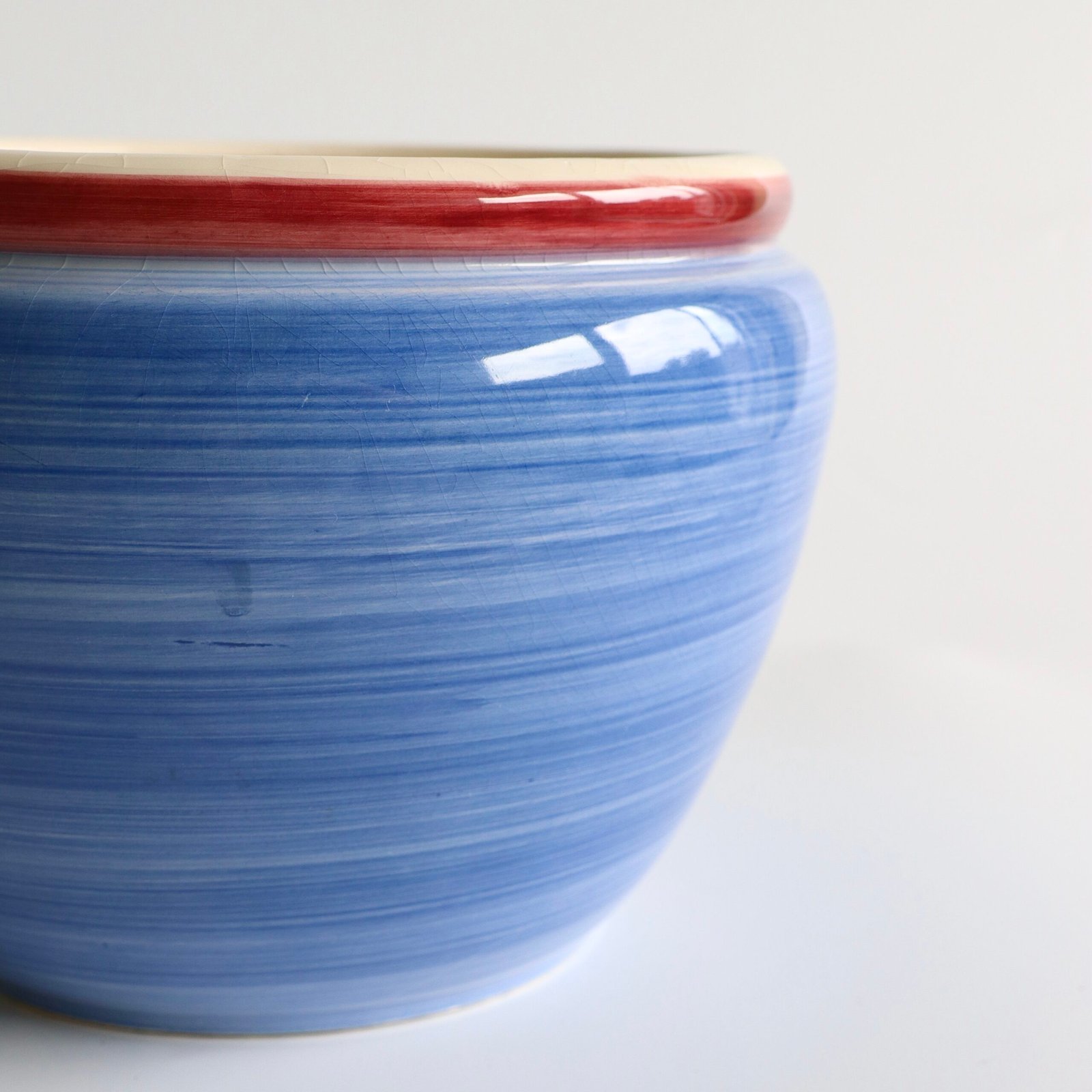 blauw streepjesglazuur en rode rand van vintage bloempot.