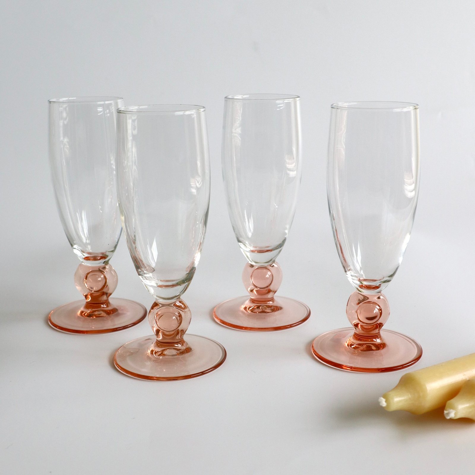 Set van vier Luminarc champagnefluites met roze glazen voeten en helder glas, vintage serviesgoed.