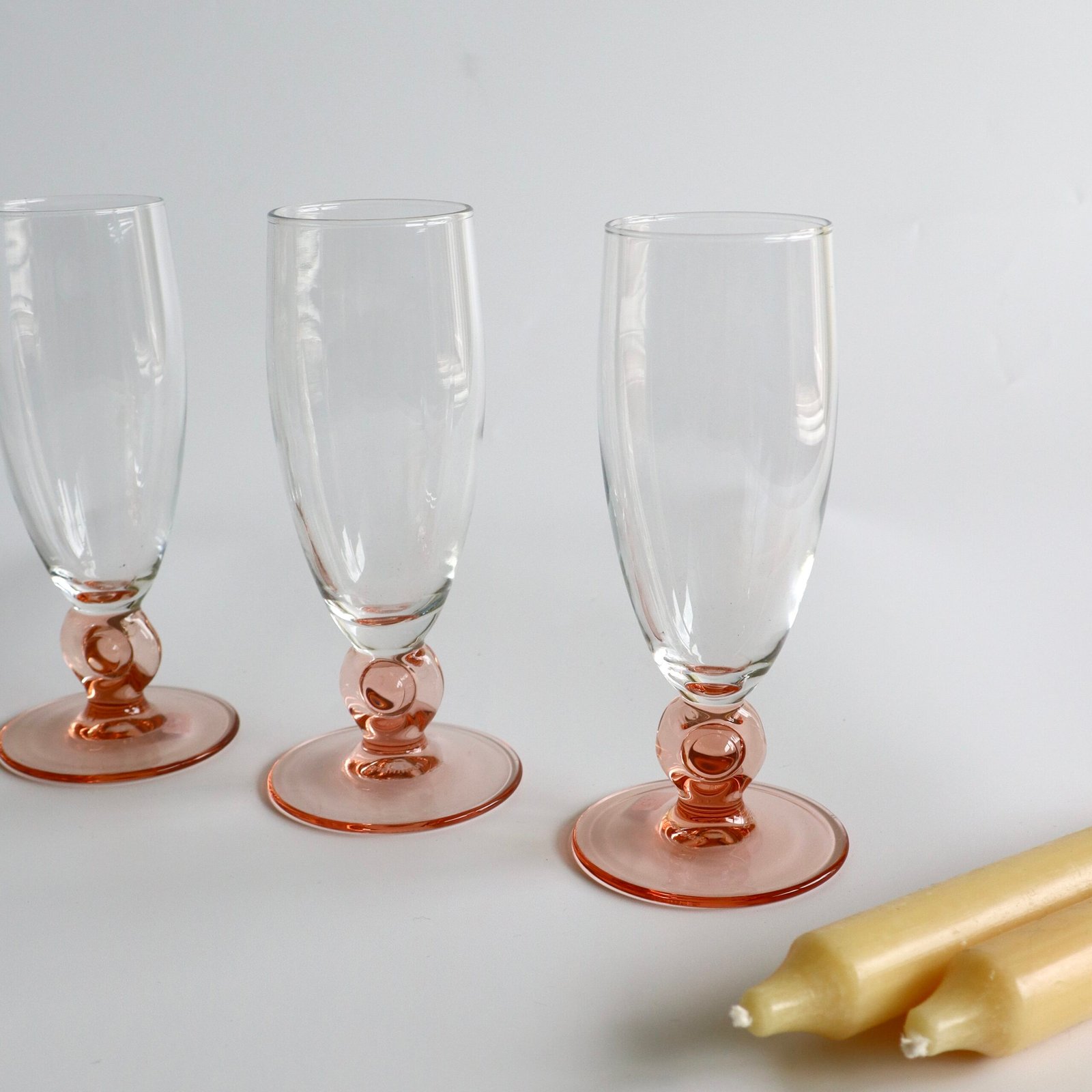 Drie Luminarc France champagnefluites met helder glas en roze gekleurde voet met bolvormig detail.