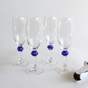 Vier vintage Luminarc champagneglazen uit Frankrijk met blauwe bolletjes aan de voet.