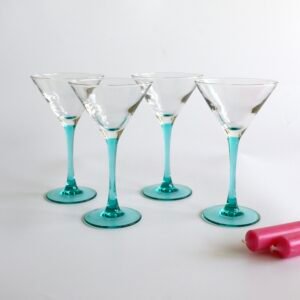 Set van vier Luminarc cocktailglazen met turquoise glazen voet en transparante kom, voorzien van decoratieve witte streeppatronen.