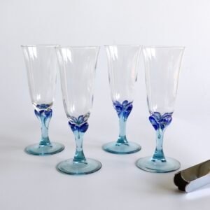 Set van vier Luminarc champagneglazen met blauw bloemmotief op lichtblauw gekleurde voet.
