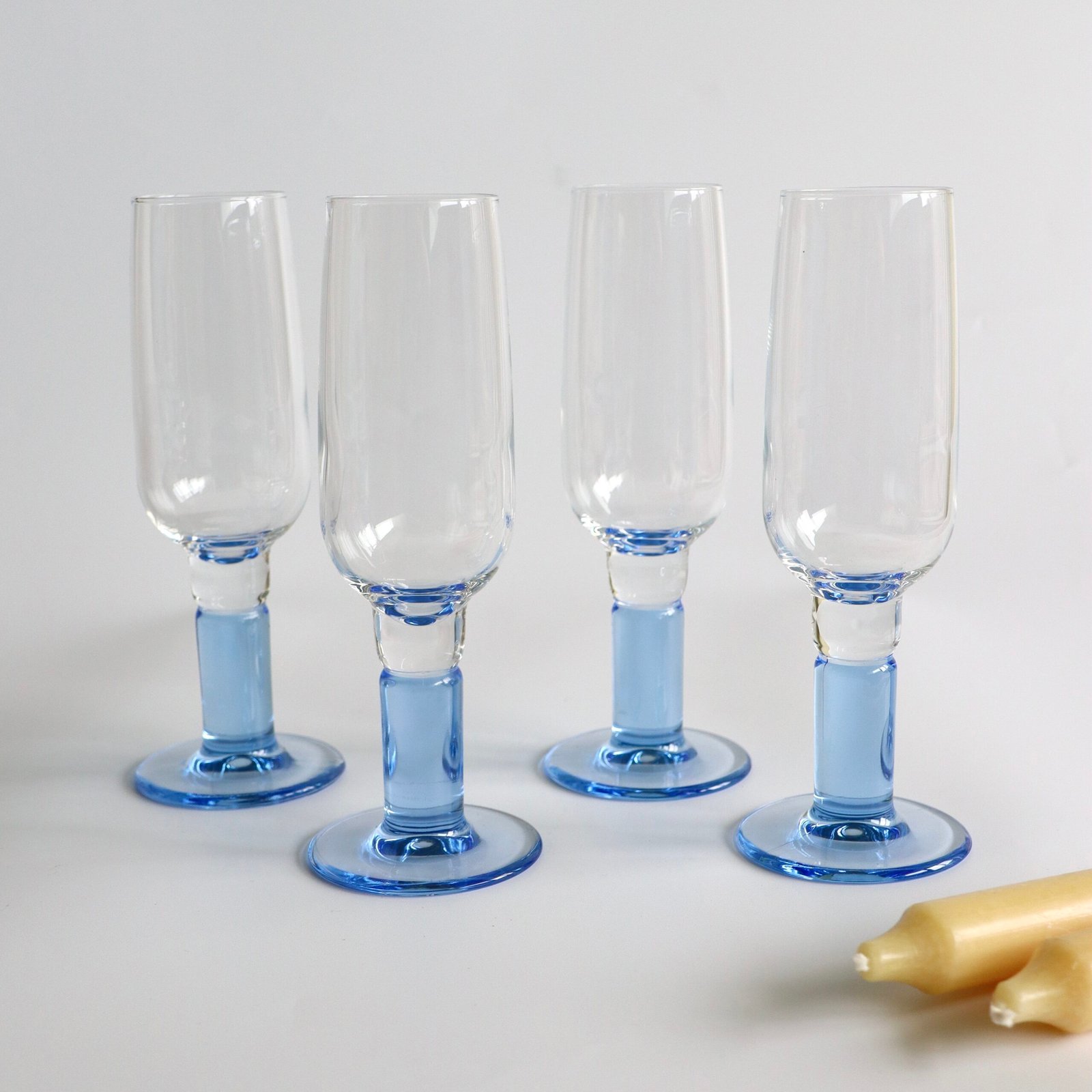 Vier Bormioli Rocco champagneglazen met lichtblauwe voet en basis, klassiek design met dik glas.