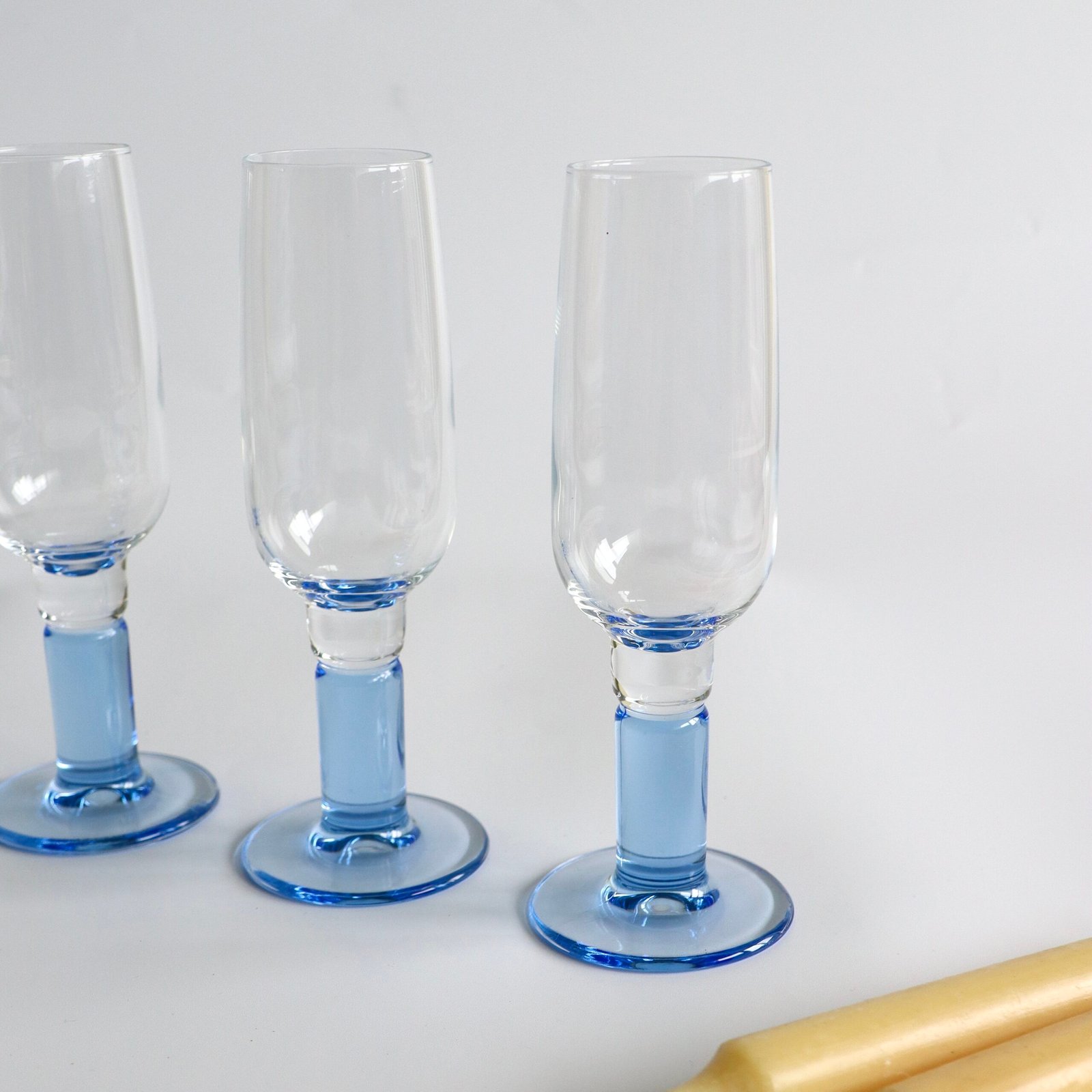 Drie Bormioli Rocco champagneglazen met lichtblauw voetje, detailweergave van de bolvormige voet.