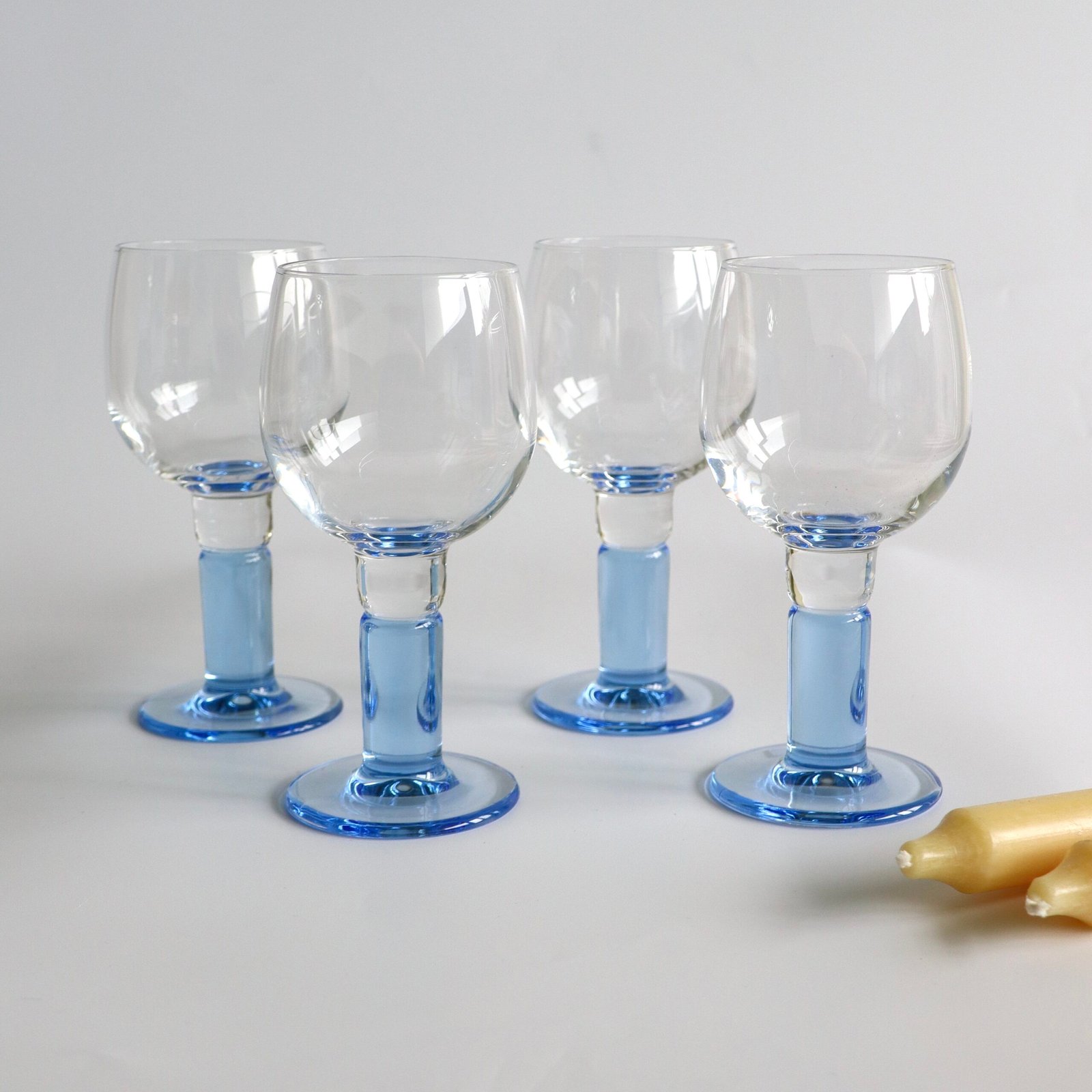 Set van vier Bormioli Rocco wijnglazen met lichtblauw gekleurde voet en stengel, klassiek vintage design.
