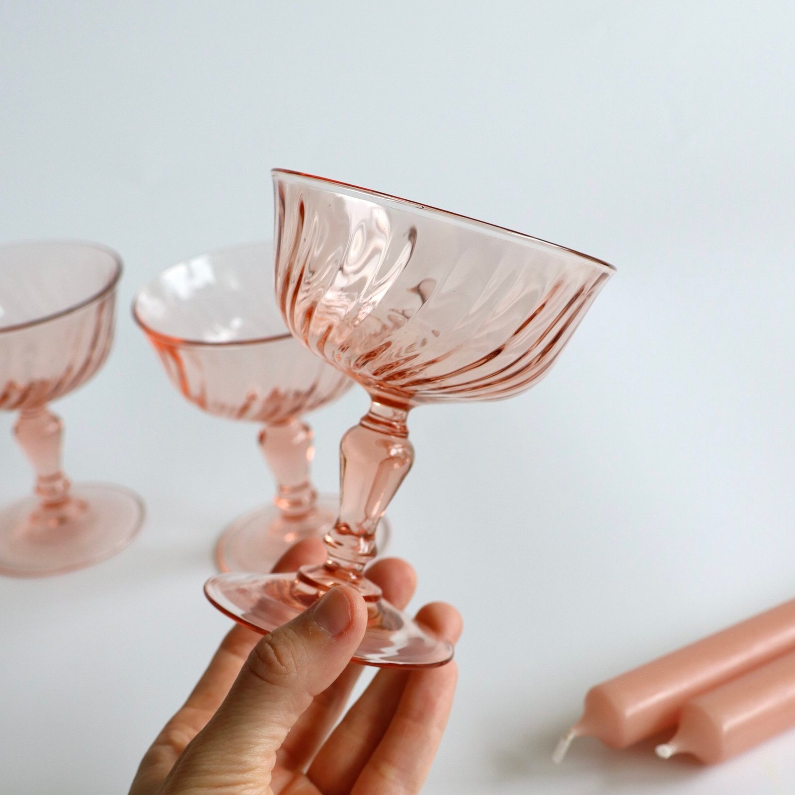 Roze Luminarc Rosaline champagnecoup in hand, zichtbaar swirl-patroon en voet van 11,5 cm hoogte.