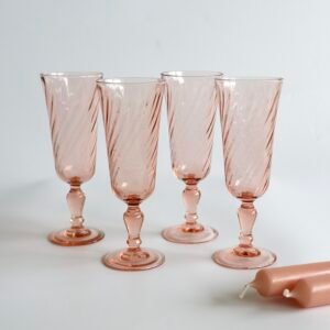 Set van vier Luminarc Rosaline champagneglazen in roze glas met gedraaid motief en voetjes, vintage Franse makij.