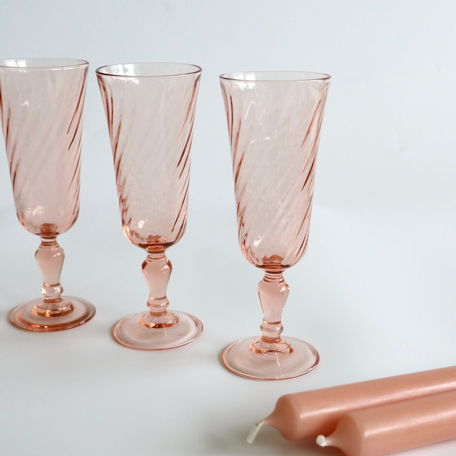 Drie Luminarc Rosaline flutes van dichtbij met karakteristieke gedraaide lijnen in het roze glas.