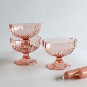 Drie roze glazen ijscoups van Luminarc France Rosaline met geribbeld patroon en voetjes.