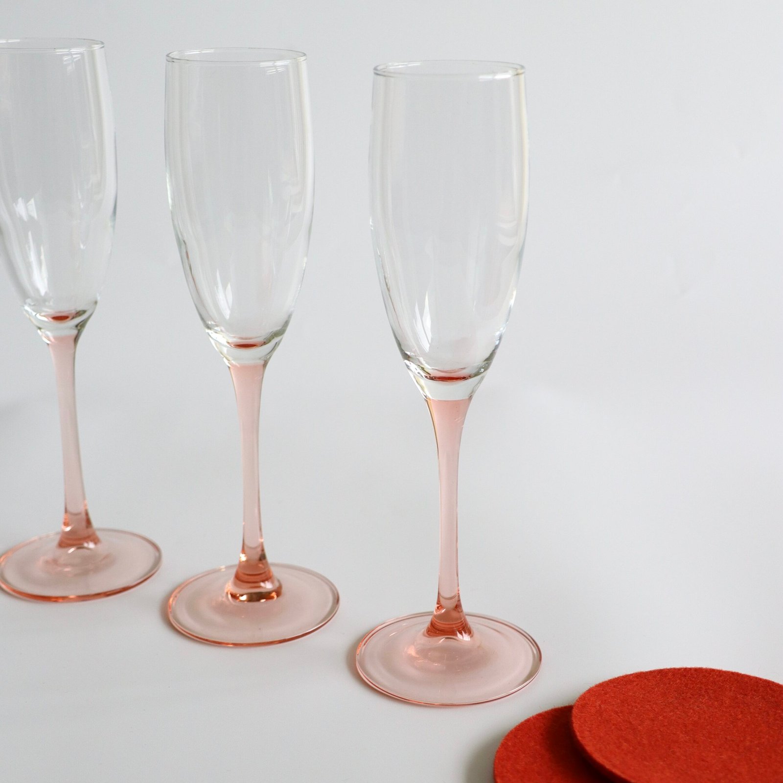 Drie Luminarc France champagnefluites met helder glas en roze voet, detail van de slanke steel.