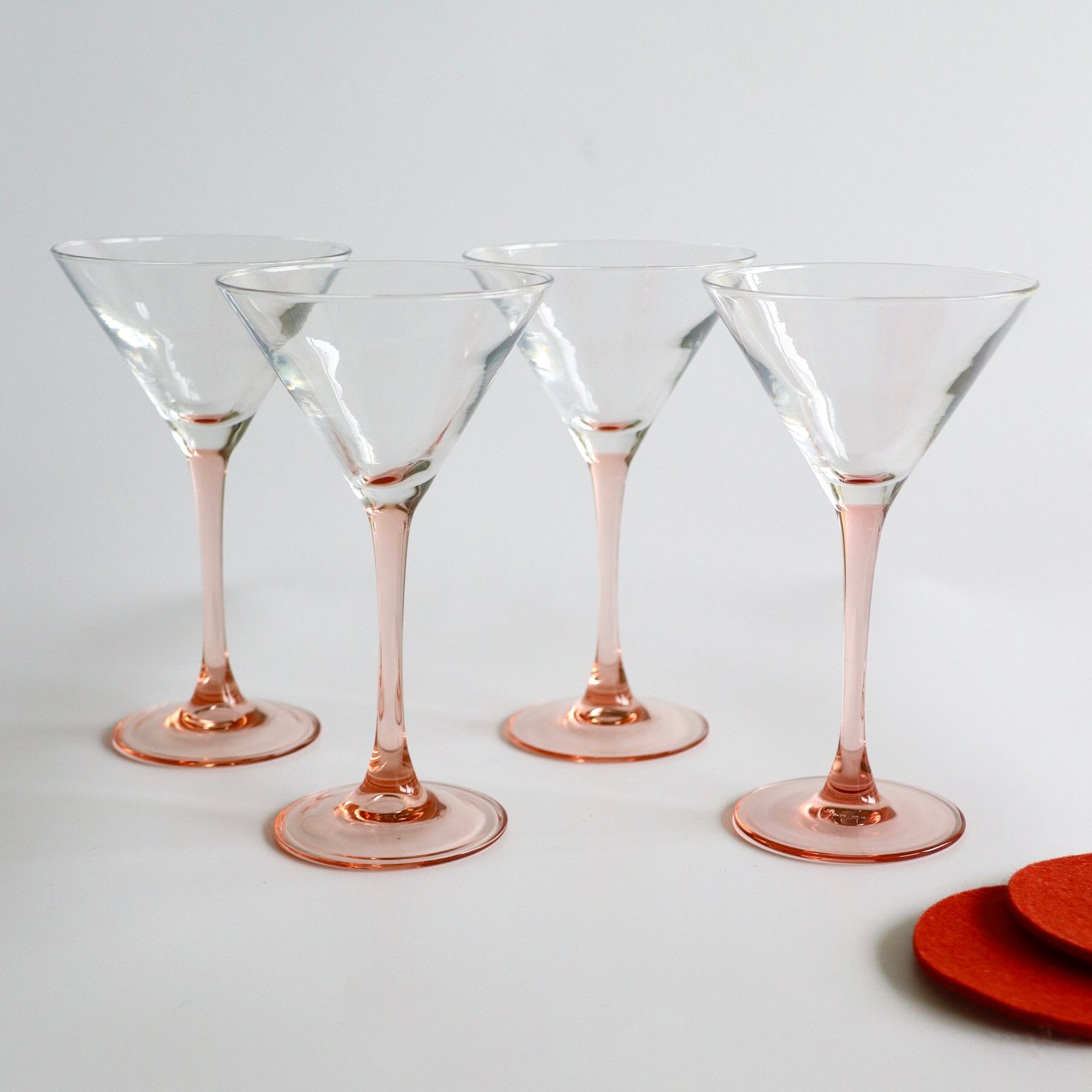 Set van vier vintage Luminarc cocktailglazen met roze voet en steng, helder glas met elegant conesvormig design.